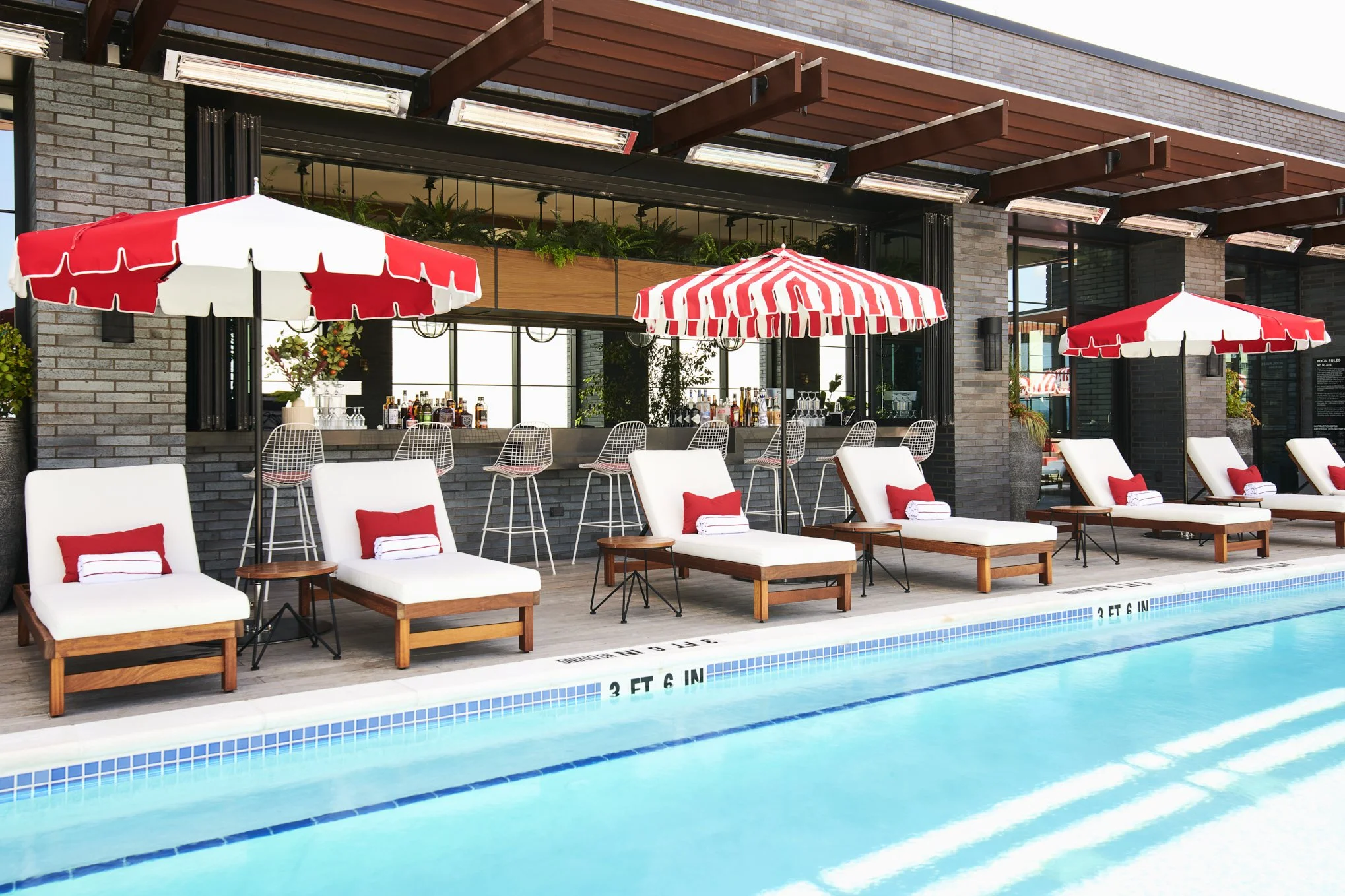 white and red pool chairs on a rooftop bar in nashville by the pool for bachelorettes