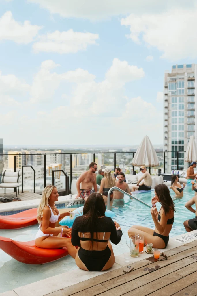 group of girls sitting on a rooftop pool in nashville