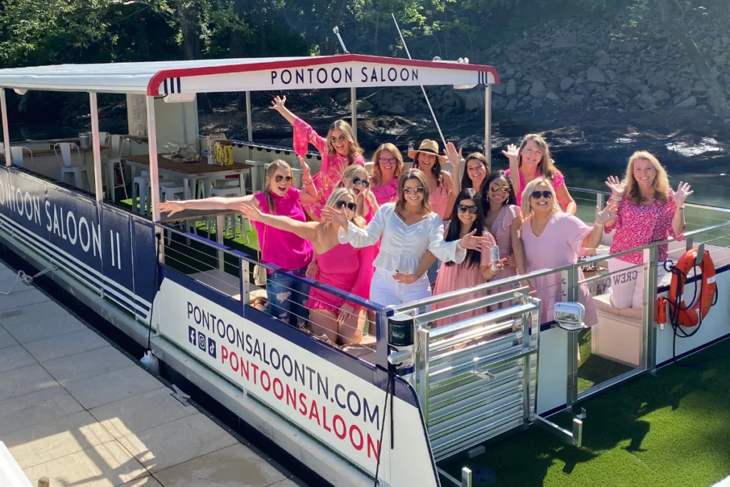 bachelorette party on pontoon in nashville, bride in white and bachelorette party in matching pink