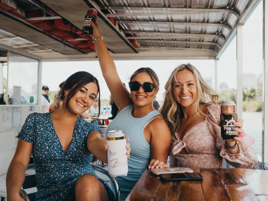 girls on a bachelorette party in nashville celebrating on a pontoon
