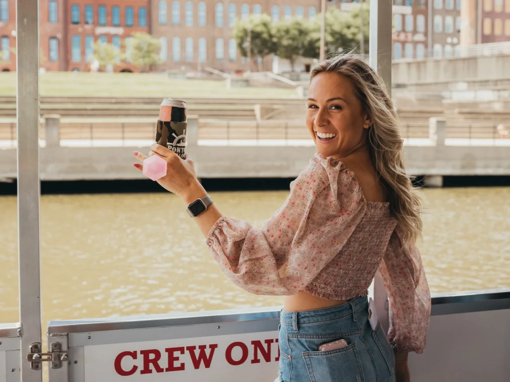 bride holding a drink on pontoon in nashville during bachelorette