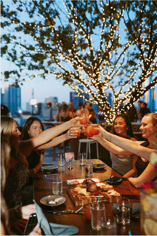 bachelorette group at la Jackson rooftop cheering cocktails